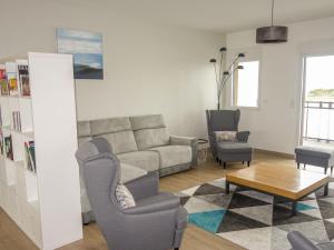 een woonkamer met een bank en 2 stoelen bij Apartment Résidence de l'Hermine by Interhome in Saint-Malo