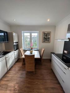 a kitchen with a table and chairs in a kitchen at Villa am Park in Bremerhaven +20 photos