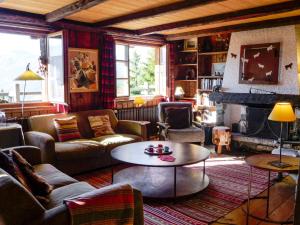 a living room with couches and a table and a fireplace at Chalet Filaos by Interhome in Verbier