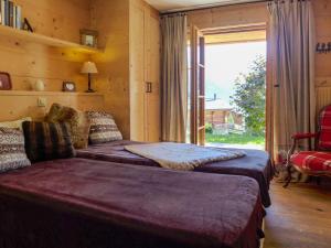 a bedroom with two beds and a large window at Chalet Filaos by Interhome in Verbier