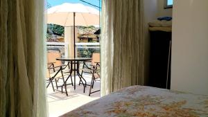 a bedroom with a balcony with a table and umbrella at Casa Sossego e Aconchego in Niterói