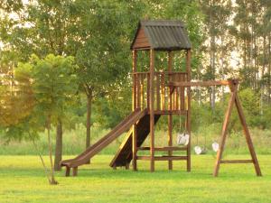 a wooden playground with a slide in a park at La Trinidad Casa de Campo in San José