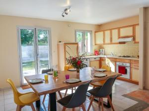 cocina con mesa de madera y sillas en Holiday Home Lana by Interhome en Denneville