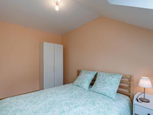1 dormitorio con 1 cama con almohadas azules en Holiday Home Lana by Interhome en Denneville