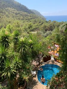 a woman sitting in a swimming pool in a resort at Turan Hill Lounge in Faralya +86 photos
