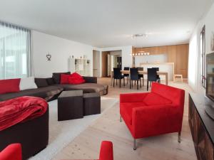 ein Wohnzimmer mit einem Sofa und einem roten Stuhl in der Unterkunft Apartment Seewiesenstrasse by Interhome in Davos