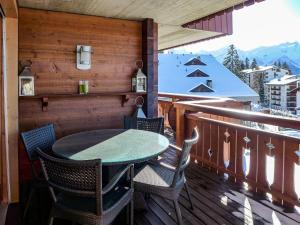 um pátio com uma mesa e cadeiras numa varanda em Apartment Pré Vert 3 by Interhome em Villars-sur-Ollon