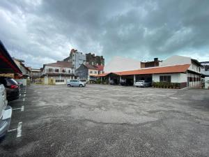 a parking lot with cars parked in front of buildings at Jawa Townstay in Malacca