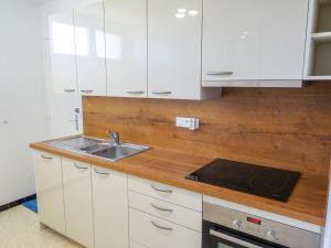 a kitchen with white cabinets and a sink at Apartment Les Cyclades-9 by Interhome in Le Lavandou +15 photos