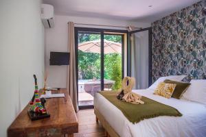 a bedroom with a bed and a table and a window at Hôtel confidentiel Le Grecale in Pianottoli-Caldarello