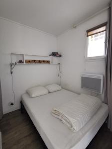 a small bedroom with a bed and a window at Domaine de la Coudoulière, T2 climatisé terrasse vue mer sans vis à vis plage à 100m in Six-Fours-les-Plages