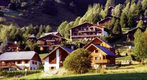 un groupe de maisons sur une colline plantée d'arbres dans l'établissement L'Edelweiss, à Aillon-le-Jeune