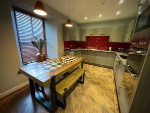 eine Küche mit einem Holztisch mit einem karierten Tisch in der Unterkunft Lower Flat, Nicolson House. in Portree