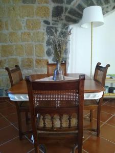 une table avec des chaises et un vase de fleurs. dans l'établissement Le Piracante, à Caiazzo
