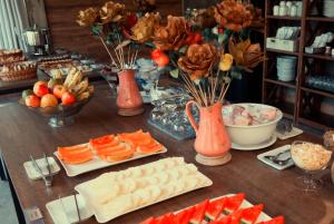 une table avec des assiettes de nourriture et des fleurs dans des vases dans l'établissement Pousada Aguas Claras, à Búzios