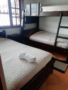 Habitación con 2 literas y una toalla en la cama en Cabañas la villa, en Villa de Leyva