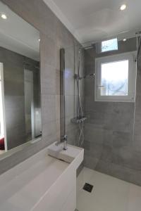 a bathroom with a sink and a shower with a mirror at Hôtel confidentiel Le Grecale in Pianottoli-Caldarello