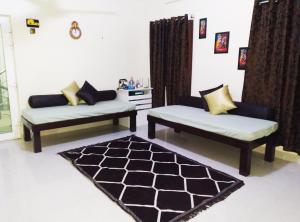 una sala de estar con 2 sofás y una alfombra en Aarudhara Holiday Home (A Home away from Home) en Pondicherry