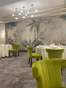 a dining room with tables and green chairs at Griff Hotel Zalau in Zalău