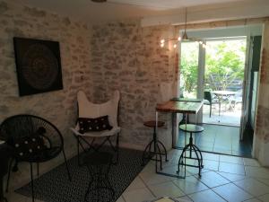 een kamer met stoelen, een tafel en een raam bij Chez Karine et Julien in Cahors