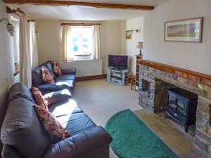 un soggiorno con divano e camino di Grange Cottage a Buckden