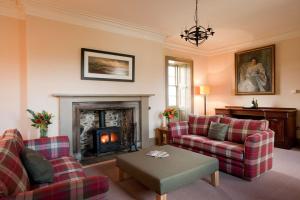 a living room with two couches and a fireplace at Balnakeil House in Balnakeil