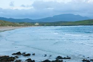 a beach with a white house in the distance at Balnakeil House in Balnakeil