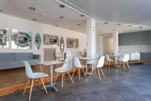 a room with tables and chairs and a couch at Hotel Roumani in Spetses