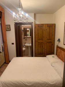 a bedroom with a large white bed and a bathroom at Hotel Firenze in Fanano