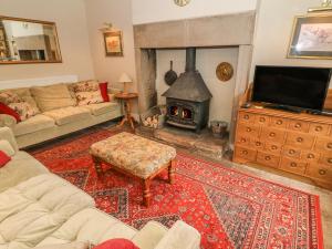 a living room with a couch and a fireplace at Beckside Cottage in Mansergh