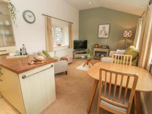 a kitchen and living room with a table and a dining room at Apple Tree Cottage in Windermere