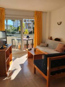 a living room with a bed and a table and a tv at APCOSTAS - Port Canigo in Roses