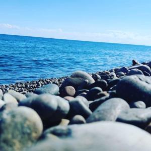 a group of rocks on a beach near the water at New Camping Coccorrocci in Marina di Gairo