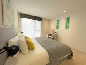 um quarto com uma cama com almofadas amarelas e uma janela em Spectacular 2 Bedroom Apartment in Great Location em Sheffield