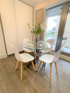 uma sala de jantar com uma mesa de vidro e cadeiras brancas em Spectacular 2 Bedroom Apartment in Great Location em Sheffield