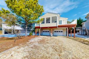 a house with a balcony on top of a yard at The Canal -- 337 Sandpiper in Bethany Beach