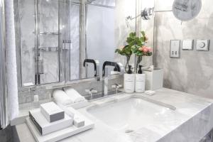 a bathroom with a sink, mirror, and soap dispenser at InterContinental Porto - Palacio das Cardosas, an IHG Hotel in Porto