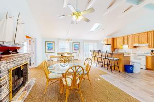 a living room with a table and chairs and a fireplace at The Canal -- 337 Sandpiper in Bethany Beach
