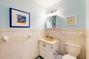 a bathroom with a toilet and a sink and a mirror at The Canal -- 337 Sandpiper in Bethany Beach +18 photos