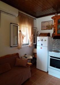 a kitchen with a couch and a white refrigerator at Mitsani Country House in Ágios Matthaíos