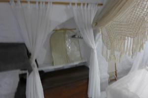 a room with white curtains and a mirror at Villa Romantica in Parikia