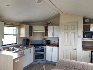 a kitchen with white cabinets and a stove top oven at Seascape in St Andrews