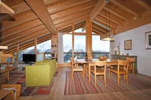 a dining room and living room with a table and chairs at Emilio Dachgeschoss in Riederalp