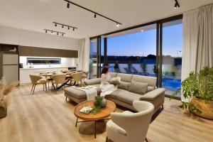 eine Frau, die auf einer Couch in einem Wohnzimmer sitzt in der Unterkunft Protaras Almaria Villa 16 in Protaras