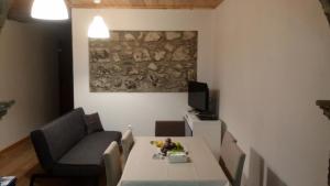 a living room with a table and a tv at By the Sea Azores in Ribeira Grande