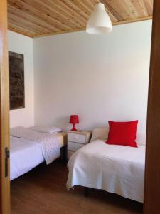 a bedroom with two beds with red pillows on them at By the Sea Azores in Ribeira Grande +76 photos