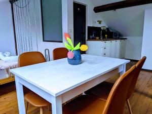 Una mesa blanca con un jarrón con flores. en Honey I`m home Apartments, en Veliko Tŭrnovo