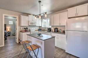 a kitchen with white cabinets and a white refrigerator at Canal Cottage Retreat with Dock and Waterfront Views in Ocean Shores
