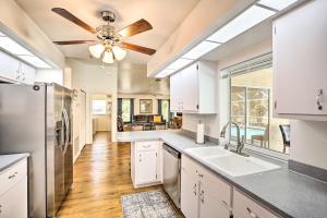 a kitchen with white cabinets and a ceiling fan at Breezy Cape Coral Oasis, Covered Lanai and BBQ in Cape Coral