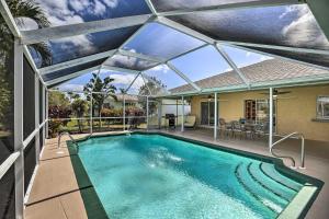 a swimming pool with a retractable roof at Breezy Cape Coral Oasis, Covered Lanai and BBQ in Cape Coral